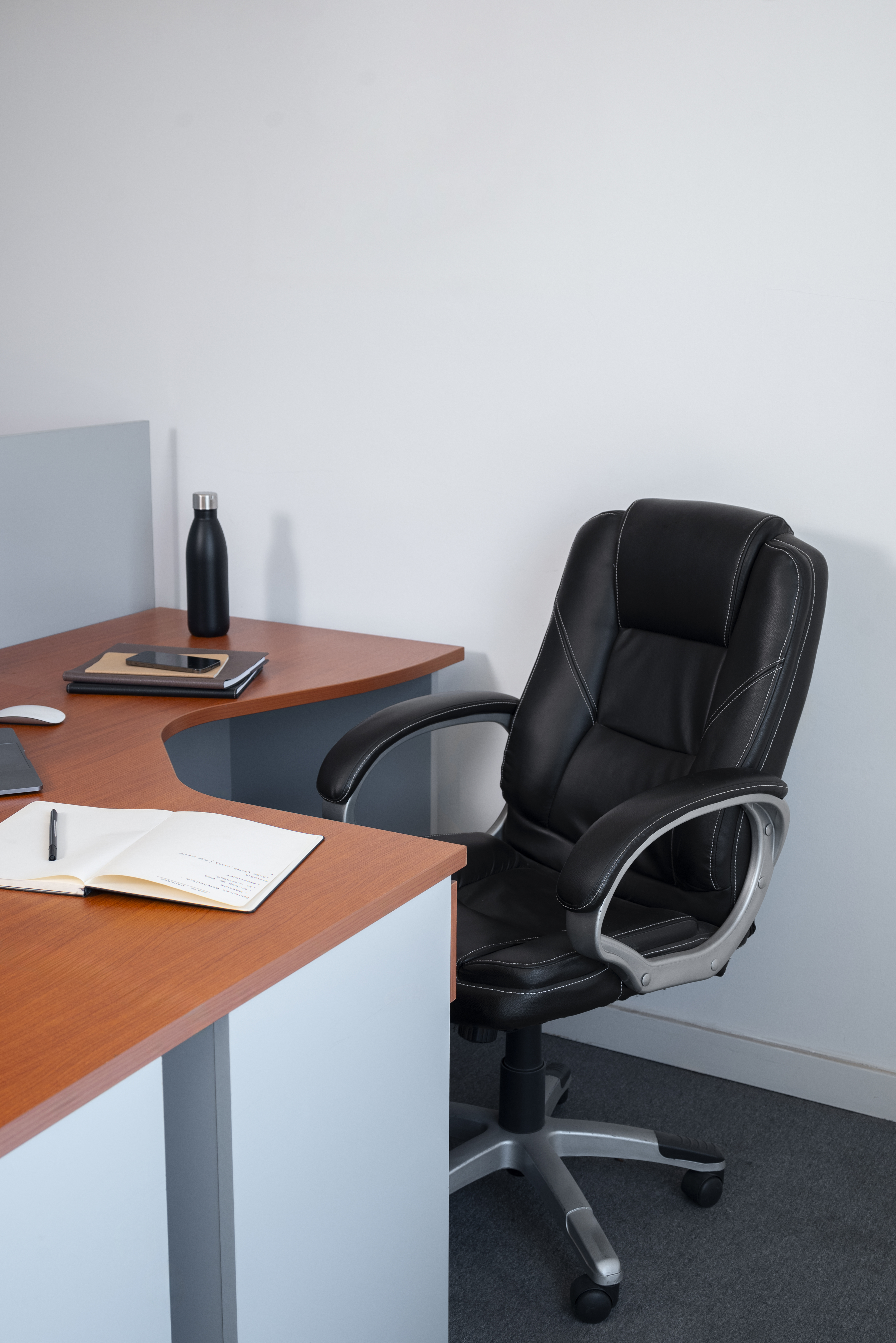 A leather chair and an L-shaped table in the office