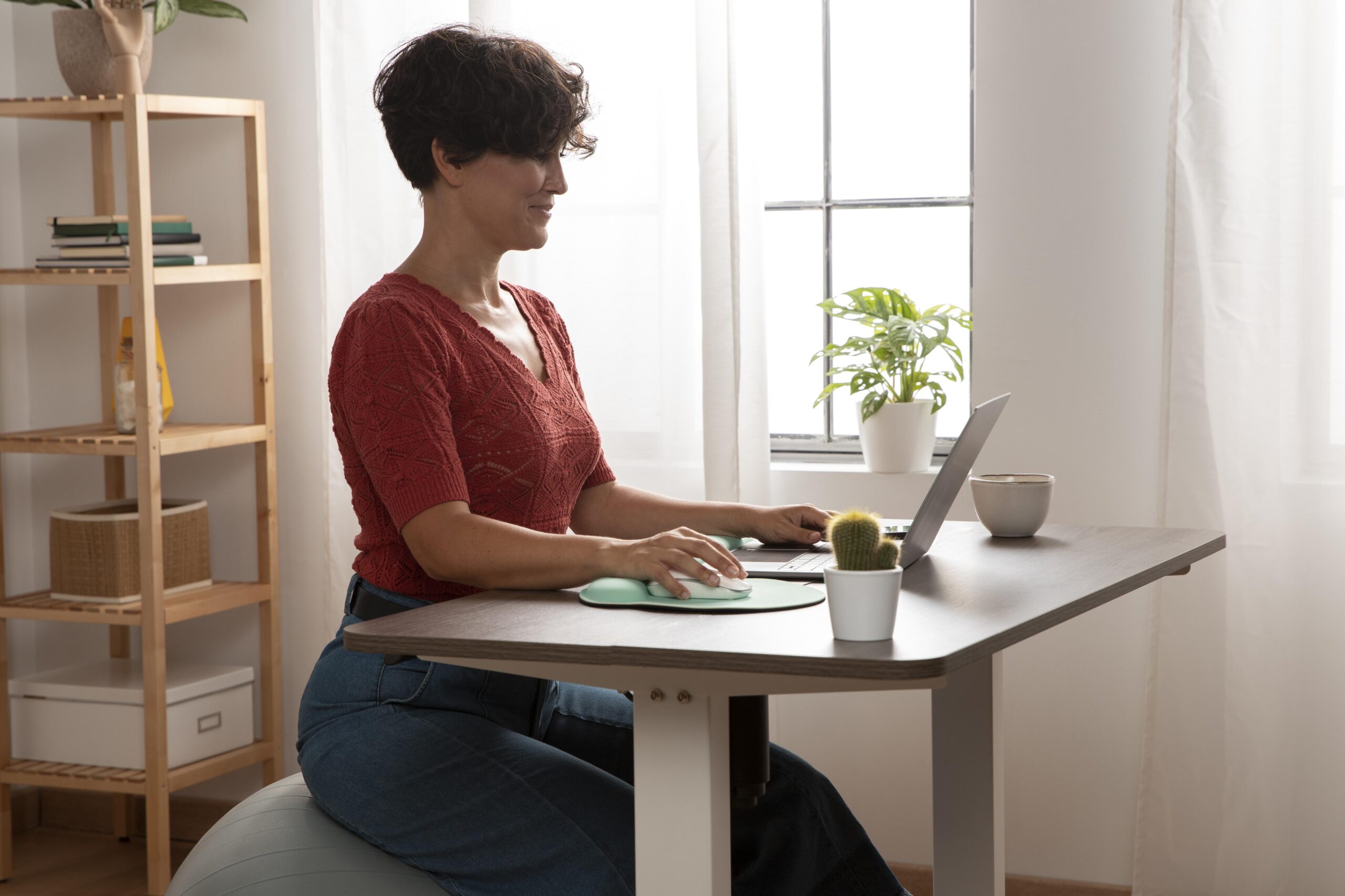 A woman sitting while working using her adjustable desk