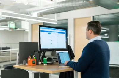 Height adjustable desks, A man standing working on his computer with a standing table