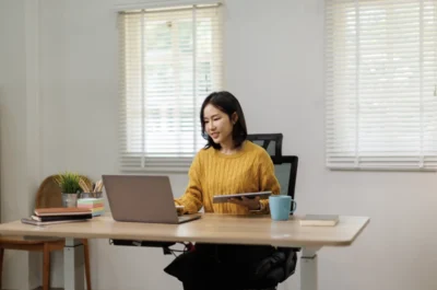 adjustable desks, A woman sitting on a mesha chair working on her adjustable table