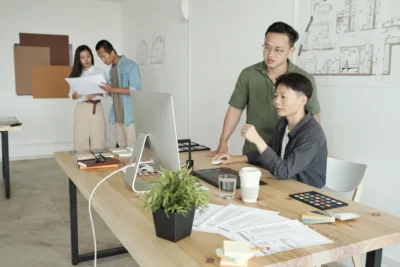 Young Asian employees working together in a modern office with office furnitures Singapore and good office chair setup.