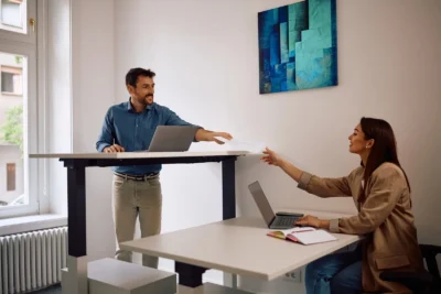 Coworkers using a Standing Desk Singapore setup.